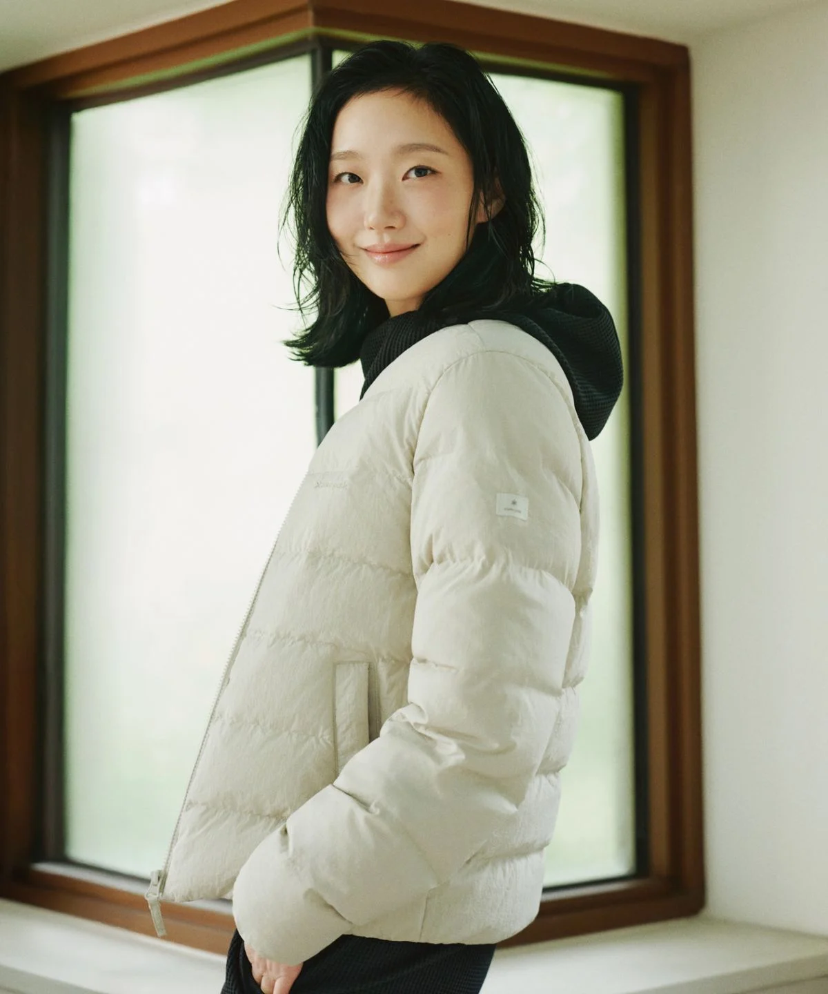 청바지에 라이트 베이지 경량 패딩을 코디하고 산책로를 걷는 전신 샷