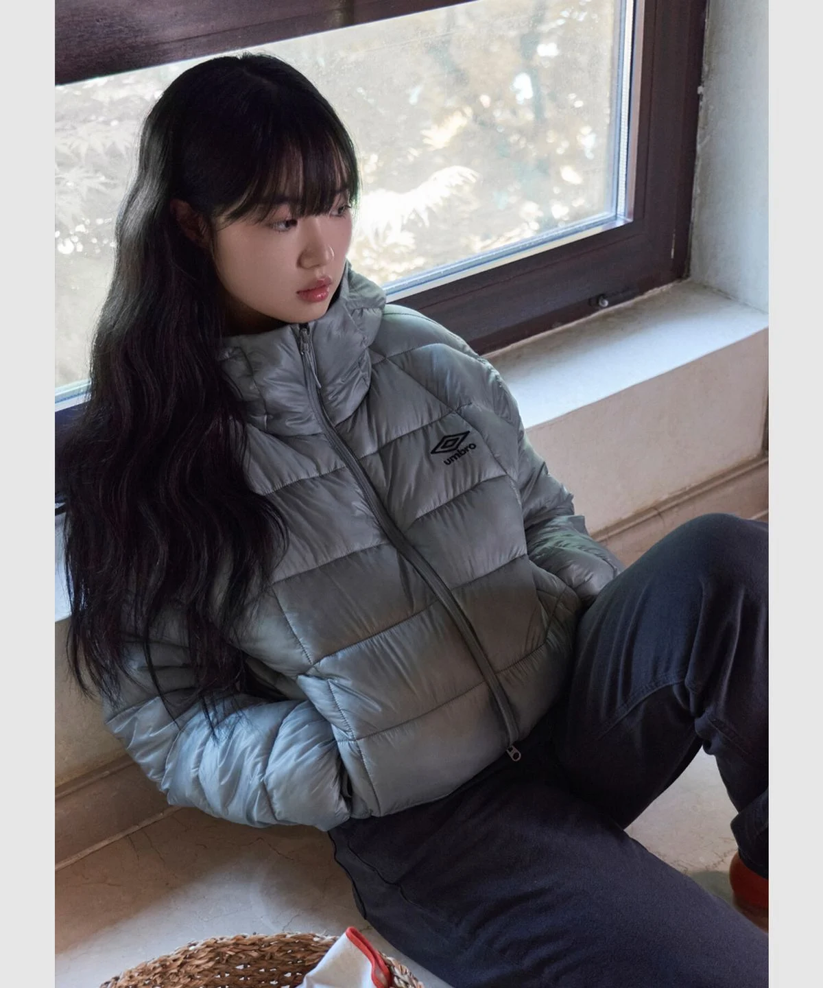 깔끔한 라이트 그레이 컬러의 엄브로 엑스레이 후드 경량 패딩 자켓이 옷걸이에 걸려 있는 전체 실루엣