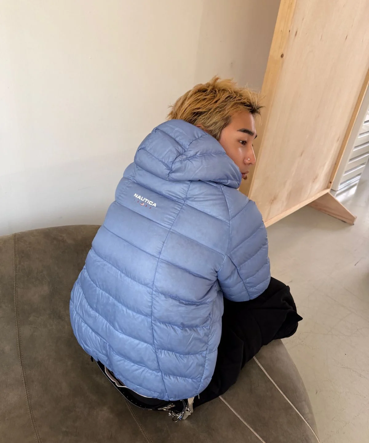 야외에서 후드를 뒤집어쓰고 바람을 막아주는 기능성을 강조한 역동적인 포즈의 사진