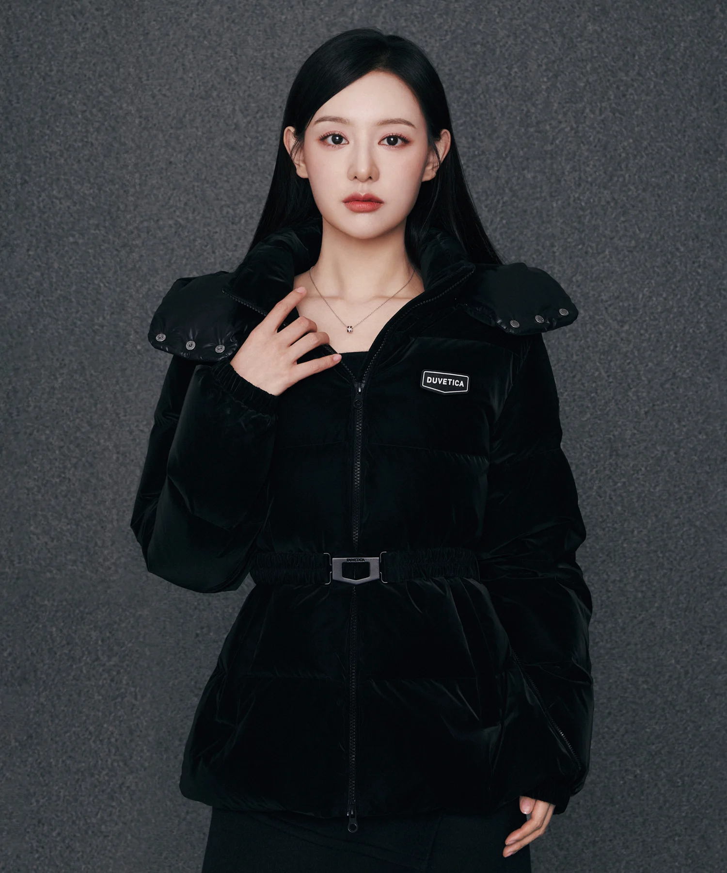 벨벳 소재 특유의 은은한 광택이 흐르는 점퍼 표면과 오각 메탈 버클 벨트 클로즈업