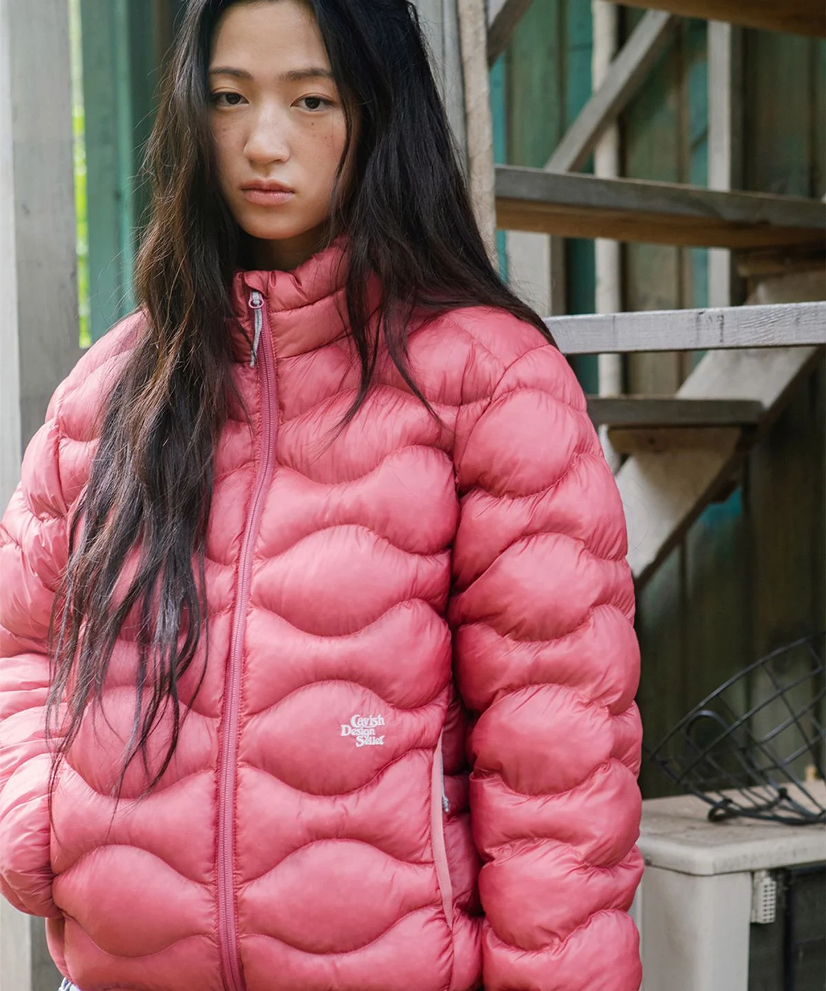 손으로 패딩 겉감을 살짝 눌렀을 때 복원되는 텐션감과 부드러운 텍스처를 클로즈업한 사진